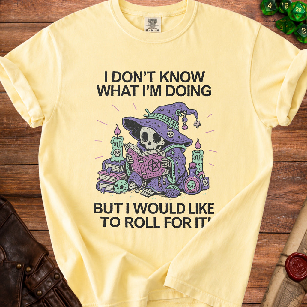 Light yellow t-shirt with a skeleton wizard reading a book and dice.