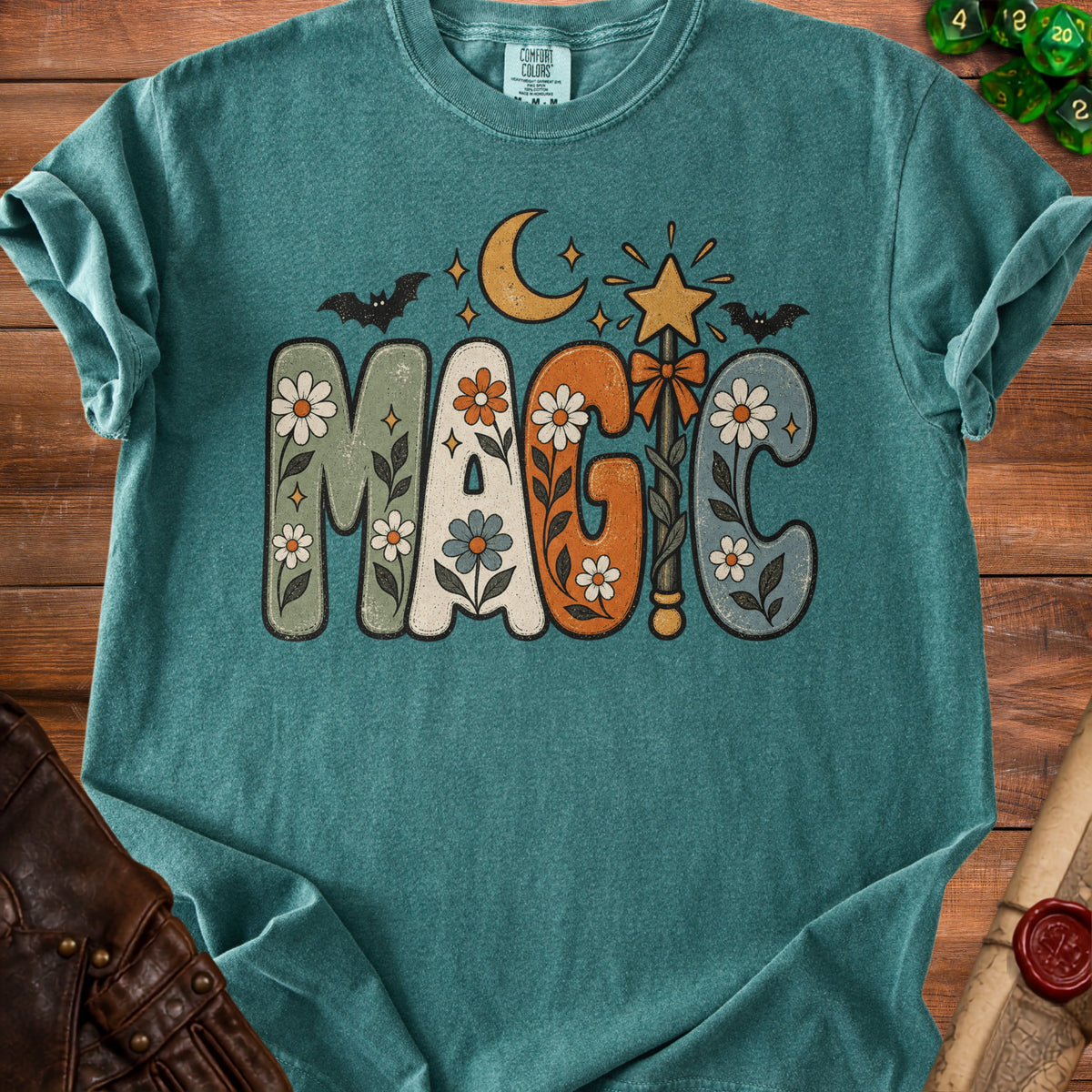 Teal t-shirt with "MAGIC" in vintage floral letters, moon, star, and bats.