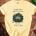 Yellow t-shirt with "Under this hard exterior lies a silly lil guy" text and graphic.