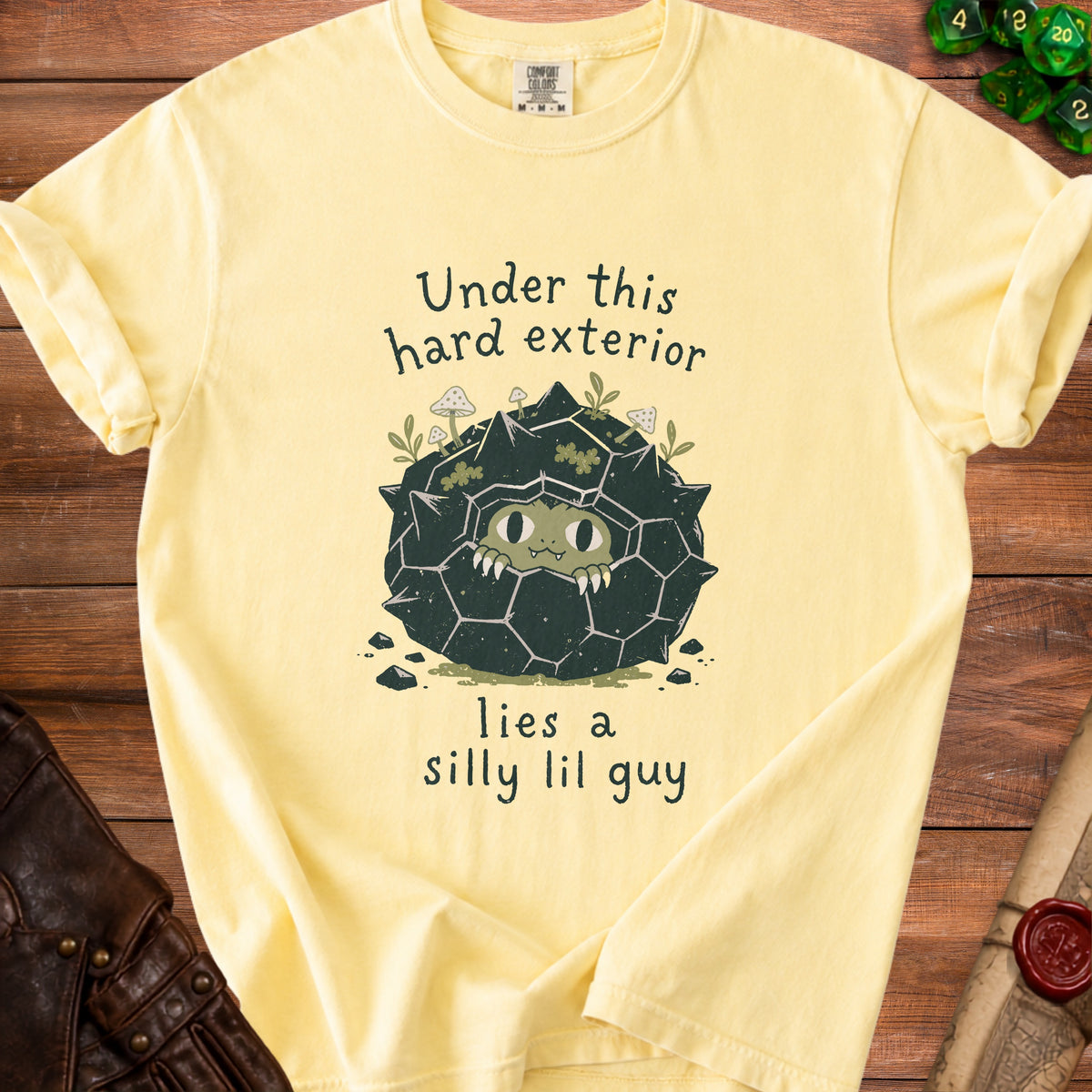 Yellow t-shirt with "Under this hard exterior lies a silly lil guy" text and graphic.