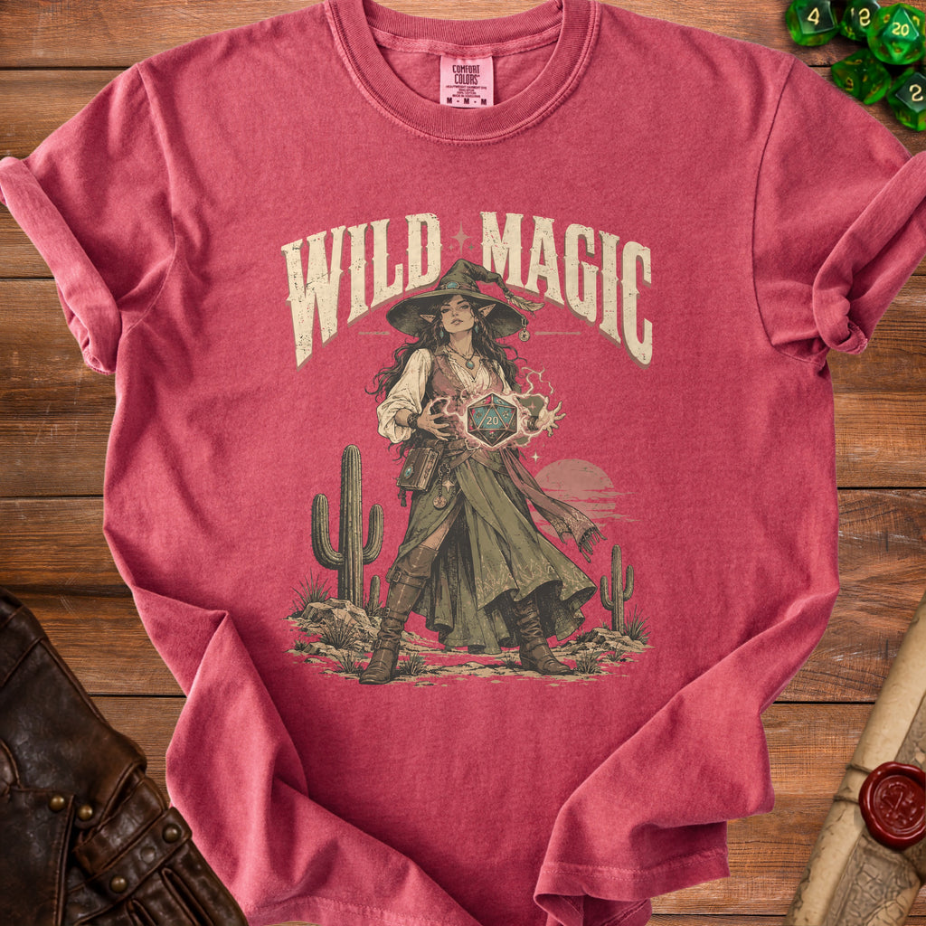 T-shirt with "Wild Magic" text, elf witch, and D20 dice graphic on desert background.