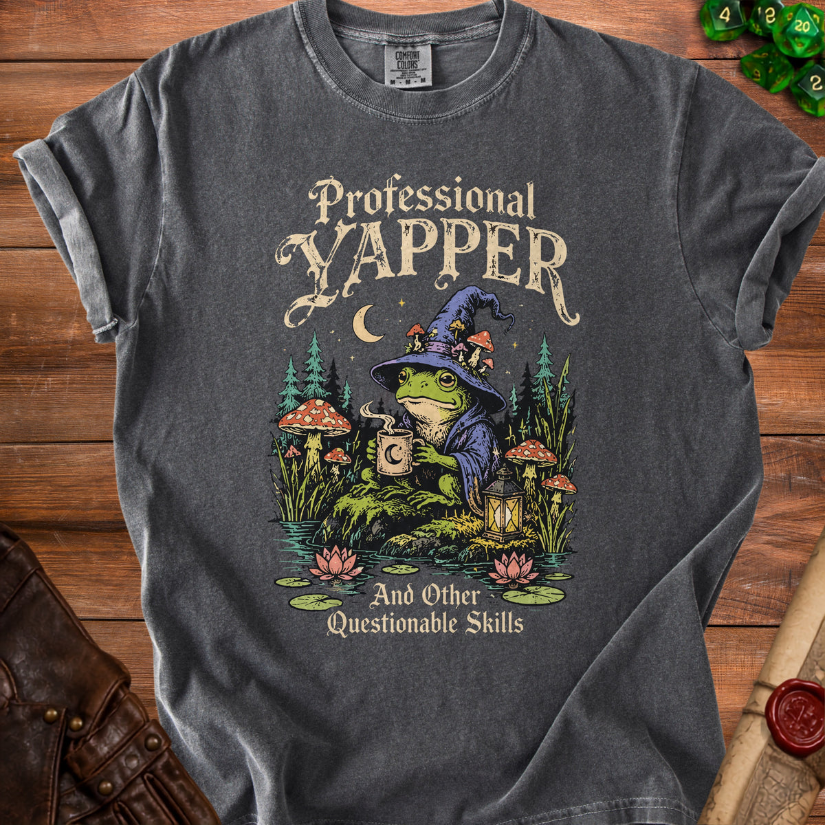 Dark gray t-shirt with "Professional Yapper And Other Questionable Skills" text and frog wizard graphic.