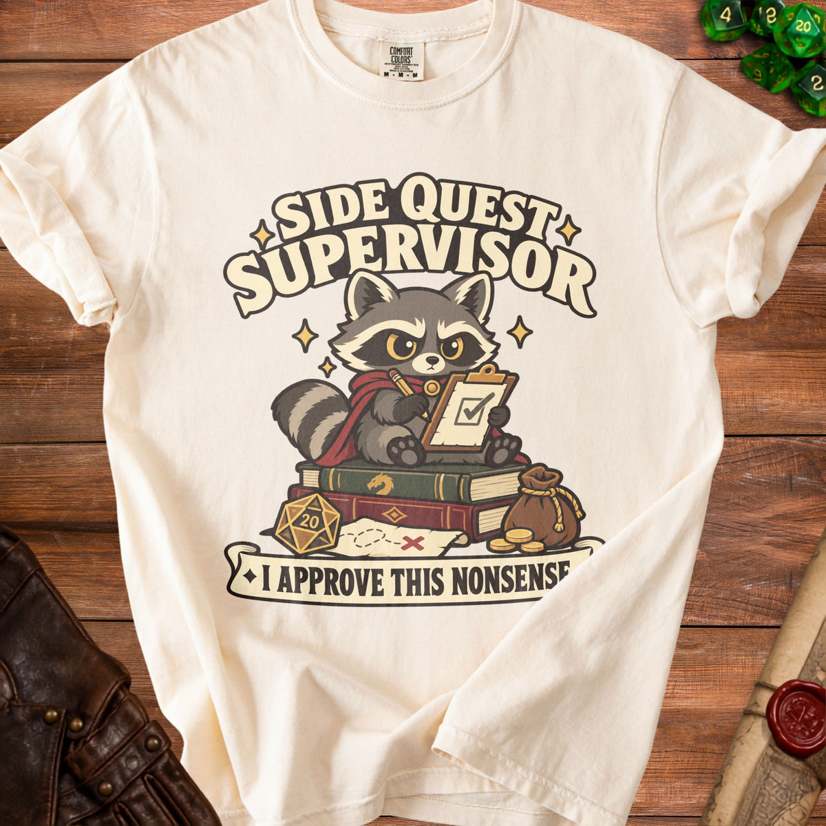 Off-white t-shirt featuring a raccoon wearing a cape and holding a clipboard, with text reading Side Quest Supervisor.