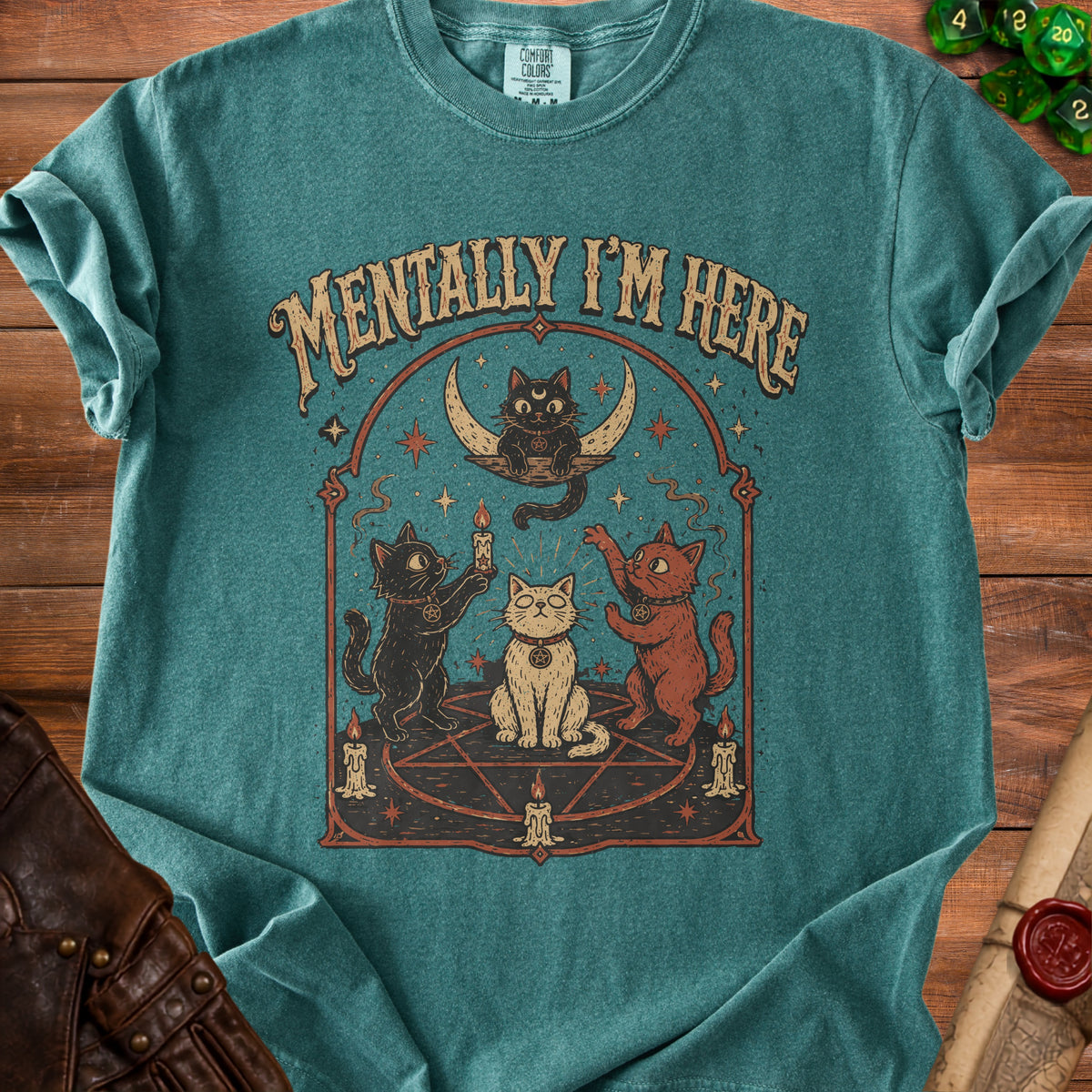 Teal t-shirt with occult cats, moon, candles, and text "MENTALLY I'M HERE".