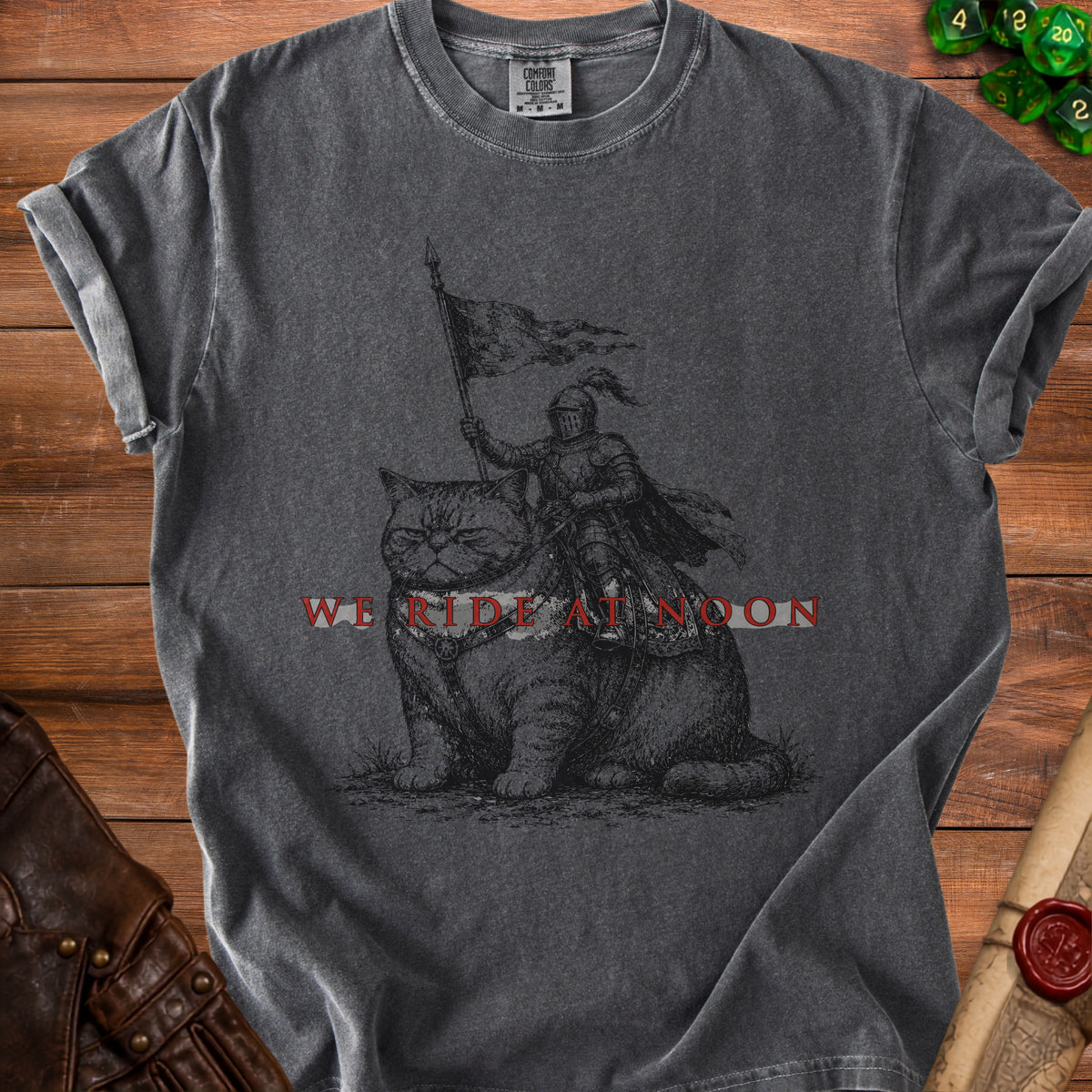 T-shirt with knight on cat graphic and "WE RIDE AT NOON" text.