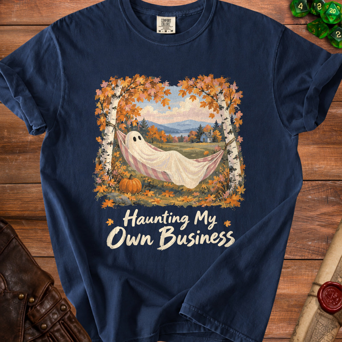 Ghost in hammock with text "Haunting My Own Business" on navy t-shirt.