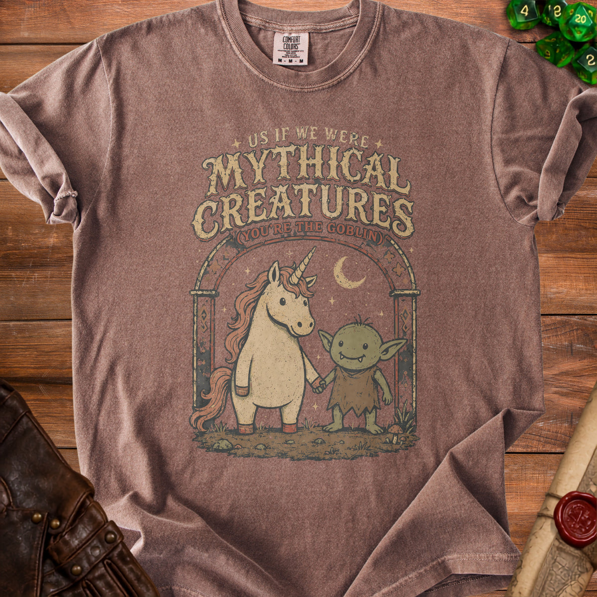 Brown t-shirt with unicorn and goblin graphic reading "Mythical Creatures (You're The Goblin)".