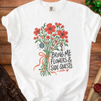 White t-shirt with a bouquet of flowers, dice, scroll, and key, with text "Bring Me Flowers & Side Quests".