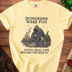 Yellow t-shirt with a knight character and text: Dungeons Were Fun Until Real Life Became the Boss Fight.