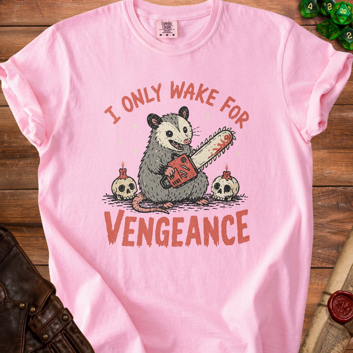 Pink t-shirt with opossum holding chainsaw, skulls, and text "I ONLY WAKE FOR VENGEANCE".