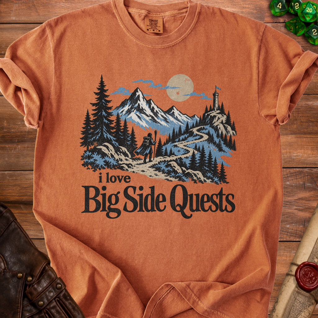 Orange t-shirt with a graphic of a hiker, mountains, and lighthouse, reads "i love Big Side Quests".