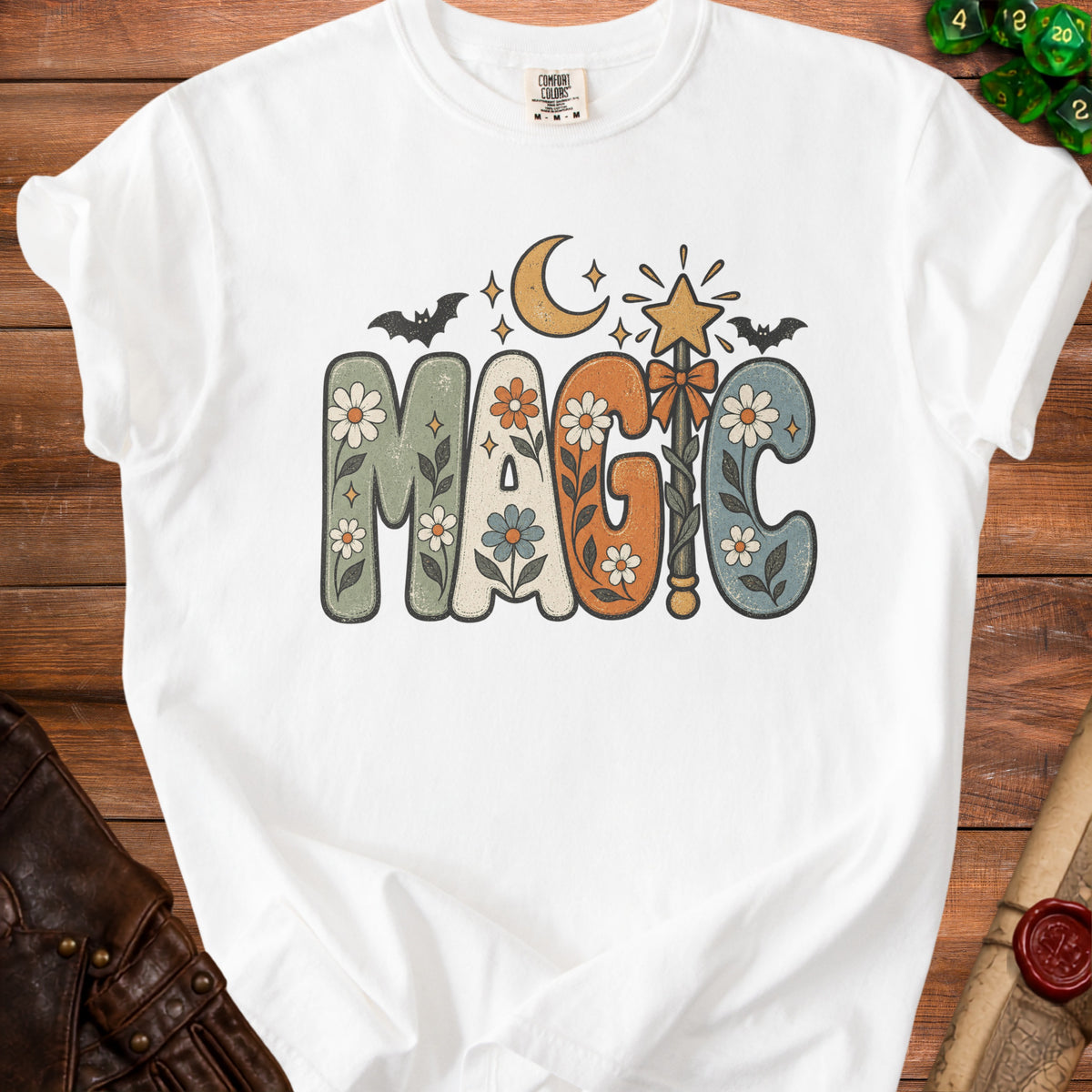 White t-shirt with "MAGIC" in floral, retro lettering, moon, bats, and stars.