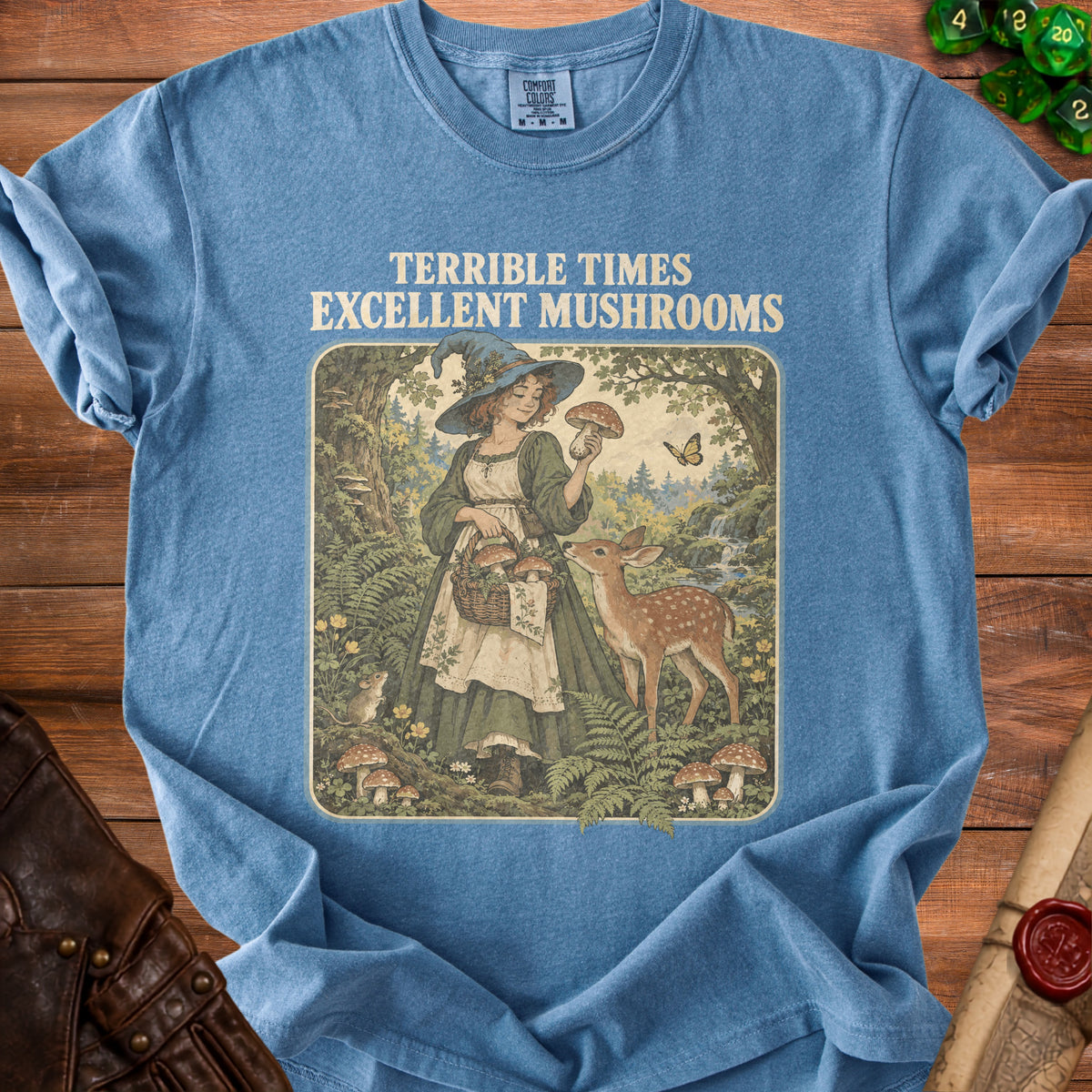 T-shirt with "Terrible Times Excellent Mushrooms" text and vintage witch picking mushrooms with deer.