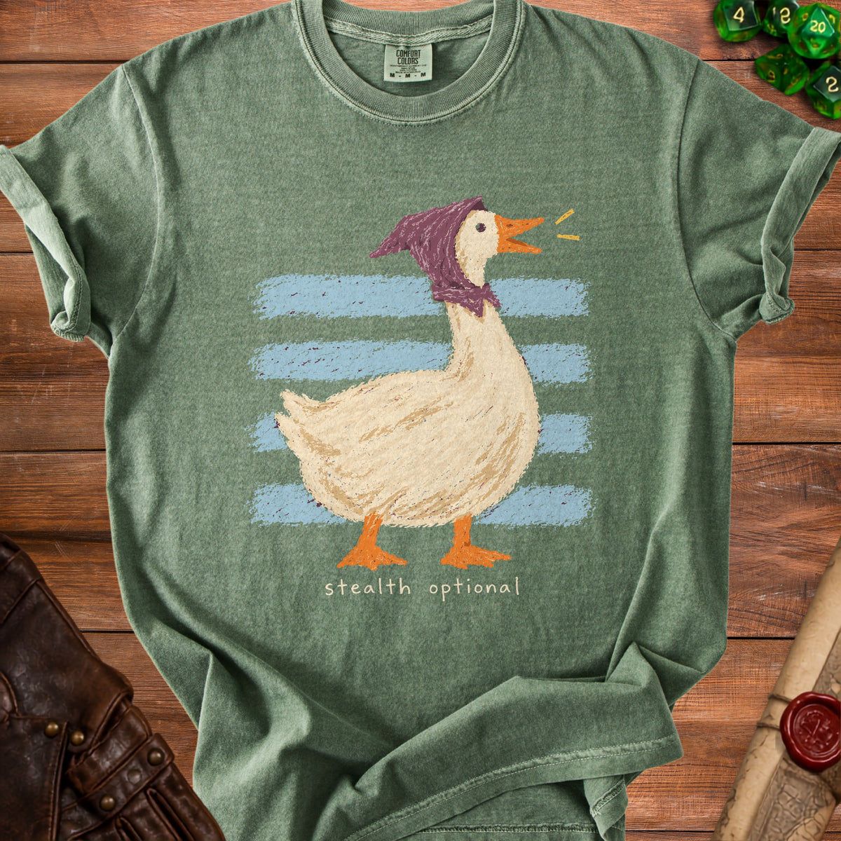 Green t-shirt with a cartoon goose wearing a purple hood and blue stripes, text "stealth optional".