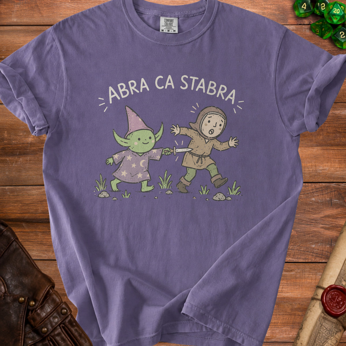 Purple t-shirt graphic: goblin wizard stabs surprised human with a knife.