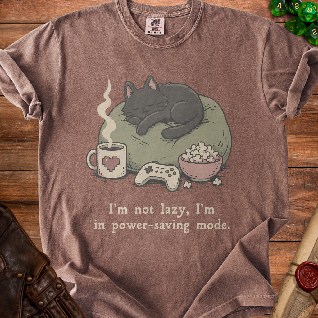 Brown t-shirt with a graphic of a sleeping cat, coffee, popcorn, and video game controller.