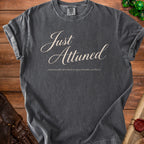 Dark grey t-shirt with "Just Attuned emotionally attached to questionable artifacts" text.