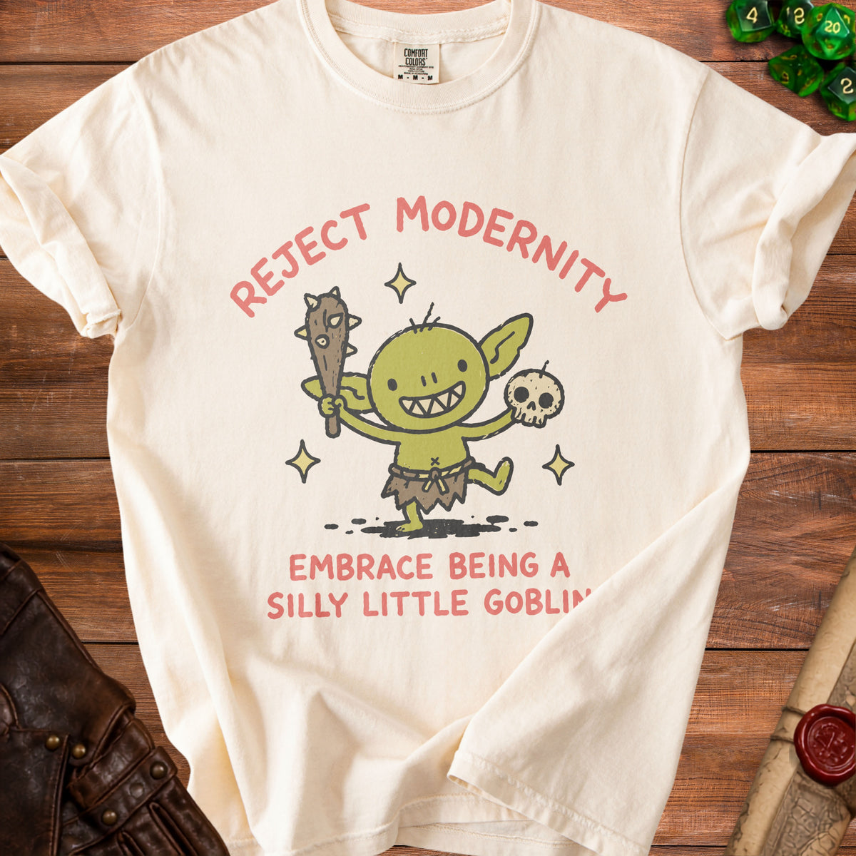 Cream t-shirt with "Reject Modernity Embrace Being a Silly Little Goblin" text and goblin graphic.