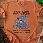 Orange t-shirt with skeleton wizard graphic and text "I DON'T KNOW WHAT I'M DOING BUT I WOULD LIKE TO ROLL FOR IT!"