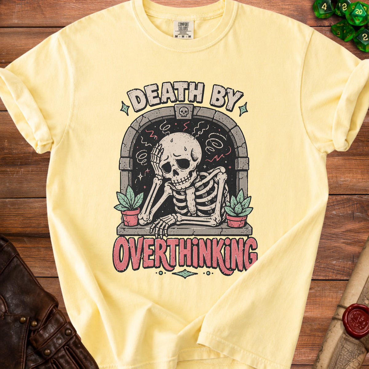 Yellow t-shirt with skeleton graphic and text "DEATH BY OVERTHINKING".