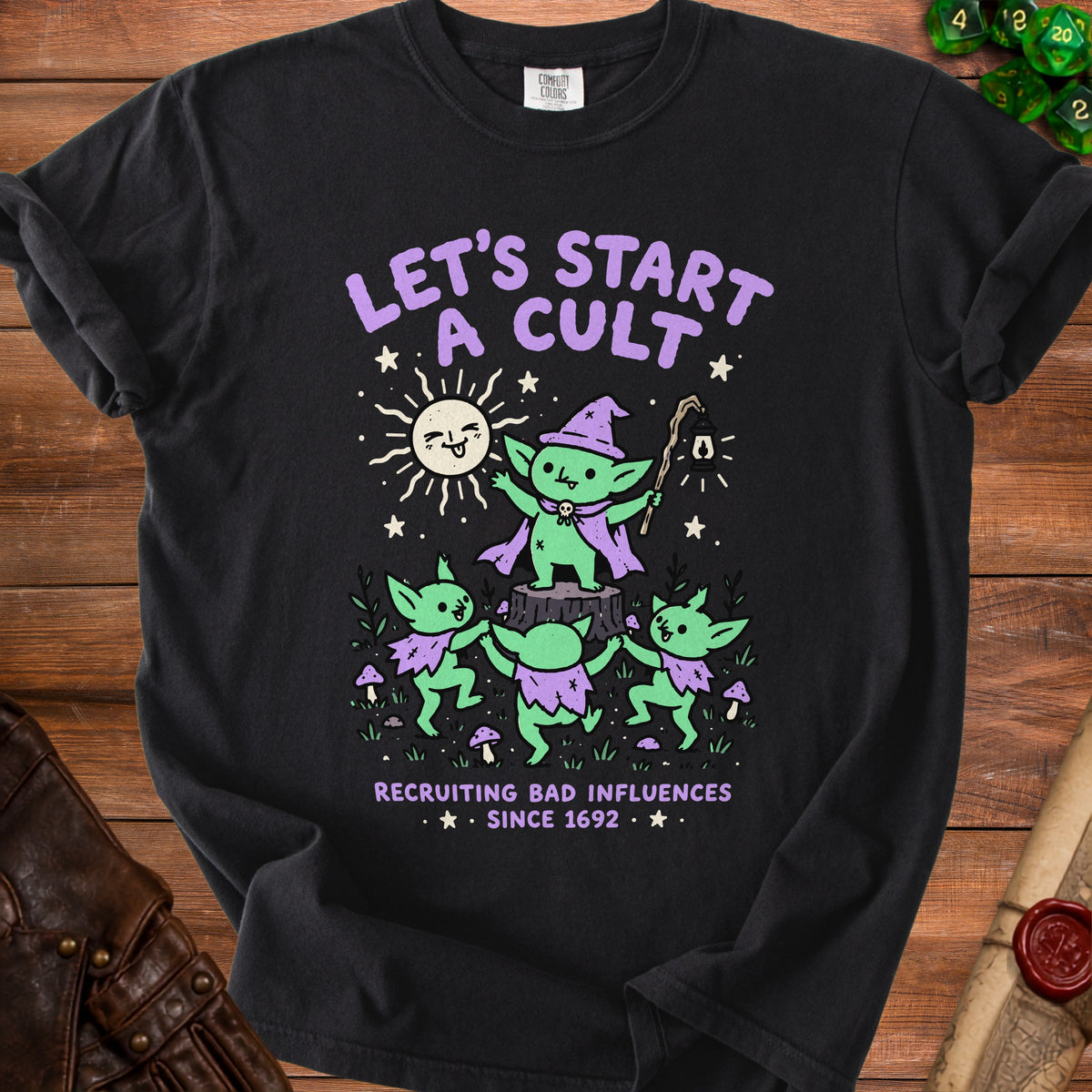 Black t-shirt with purple text "LET'S START A CULT RECRUITING BAD INFLUENCES SINCE 1692".
