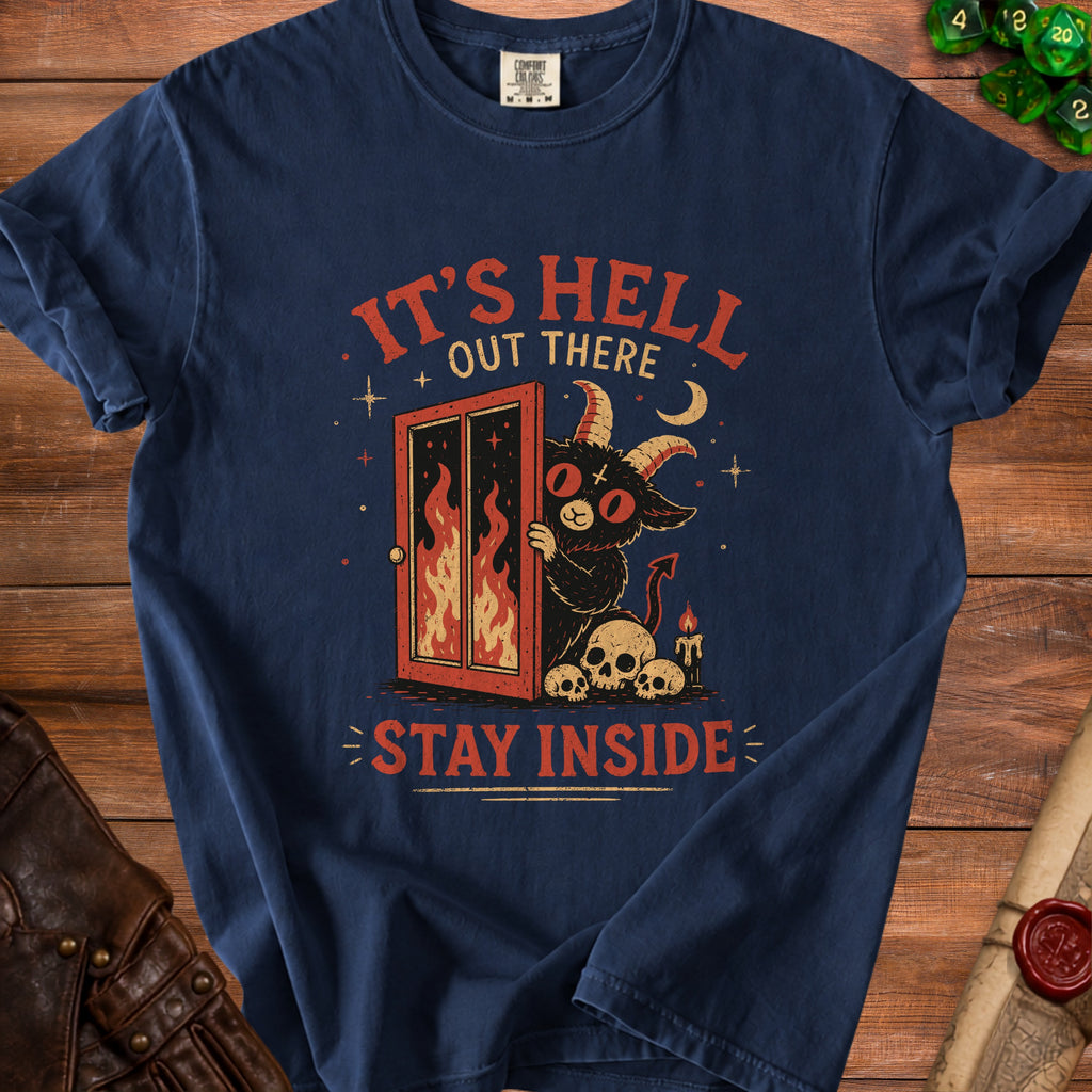 Navy t-shirt with a graphic of a demon peeking through a fiery door, skulls, and text "It's Hell Out There Stay Inside."