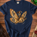 Cowgirl riding a moth with patterned wings on a dark blue shirt.