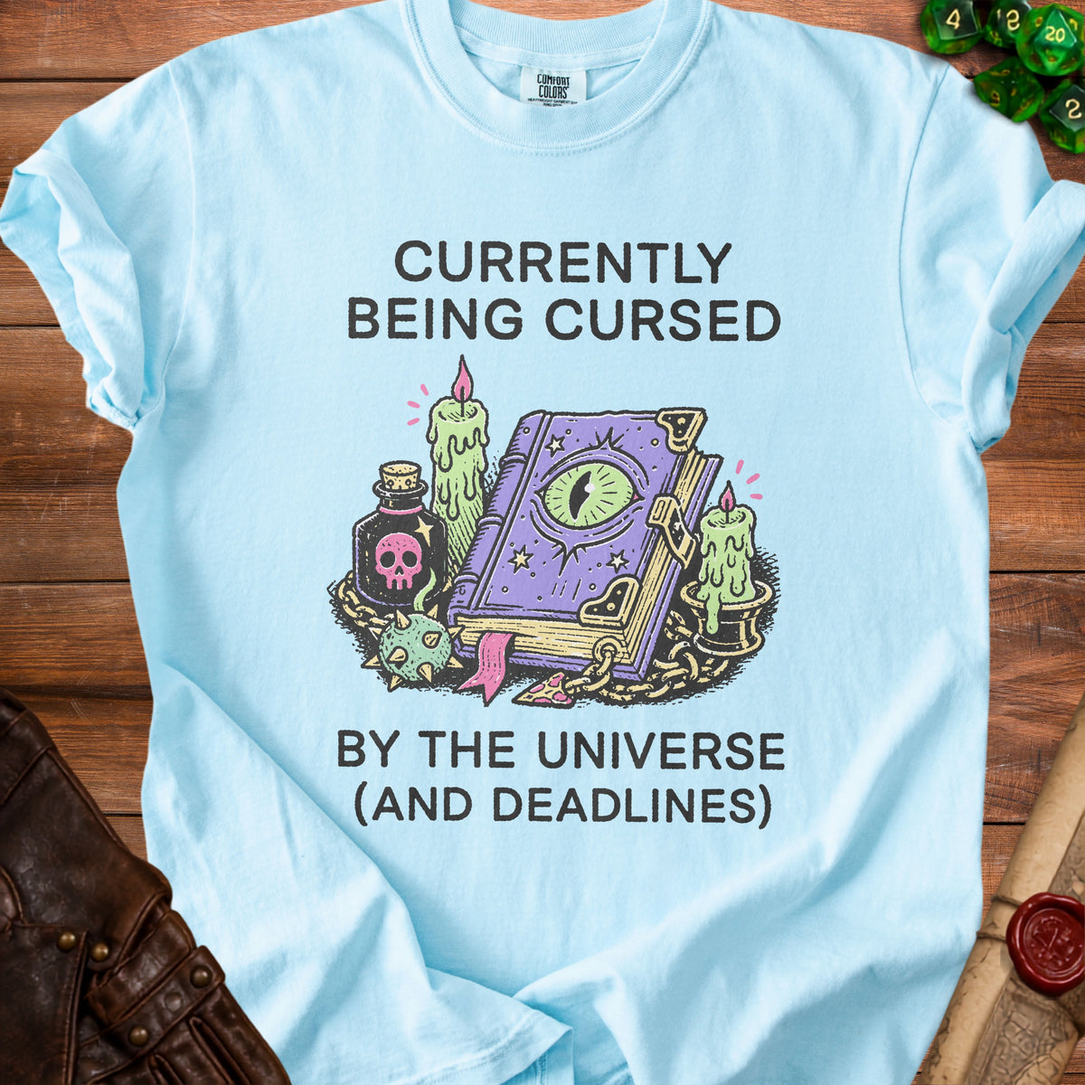 Light blue t-shirt with "Currently Being Cursed by the Universe (And Deadlines)" text.