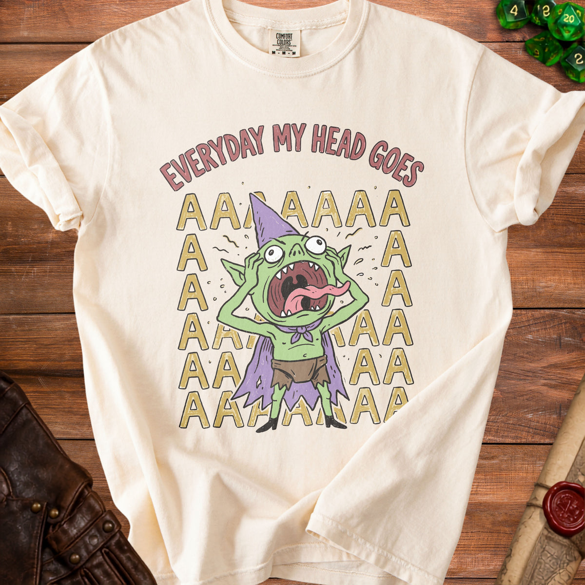 Cream t-shirt with green goblin character screaming, text "EVERYDAY MY HEAD GOES".