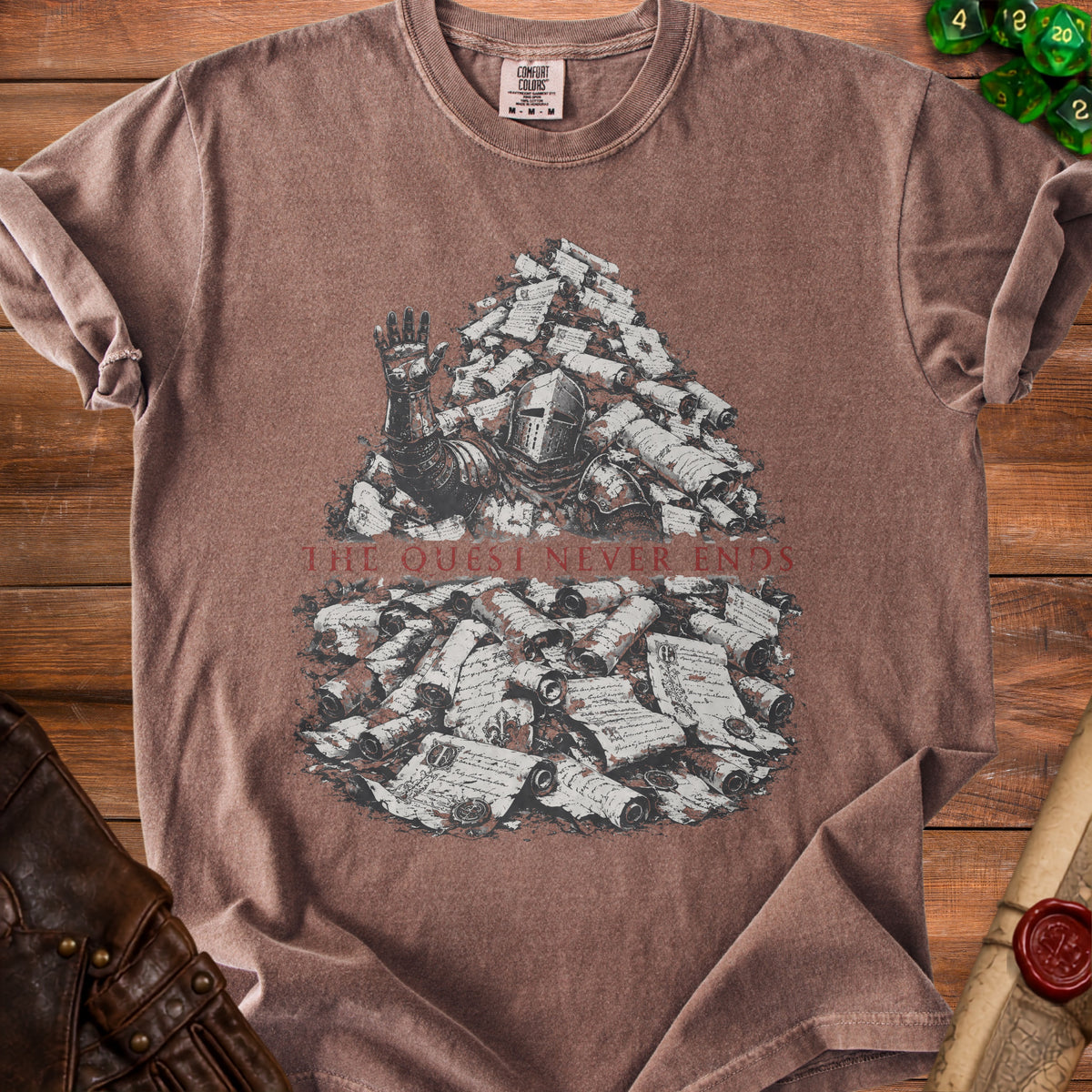 Brown t-shirt with knight buried in scrolls graphic and "THE QUEST NEVER ENDS" text.