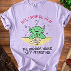 Light purple t-shirt with a green creature and text that reads "BOY, I SURE DO WISH THE HORRORS WOULD STOP PERSISTING."
