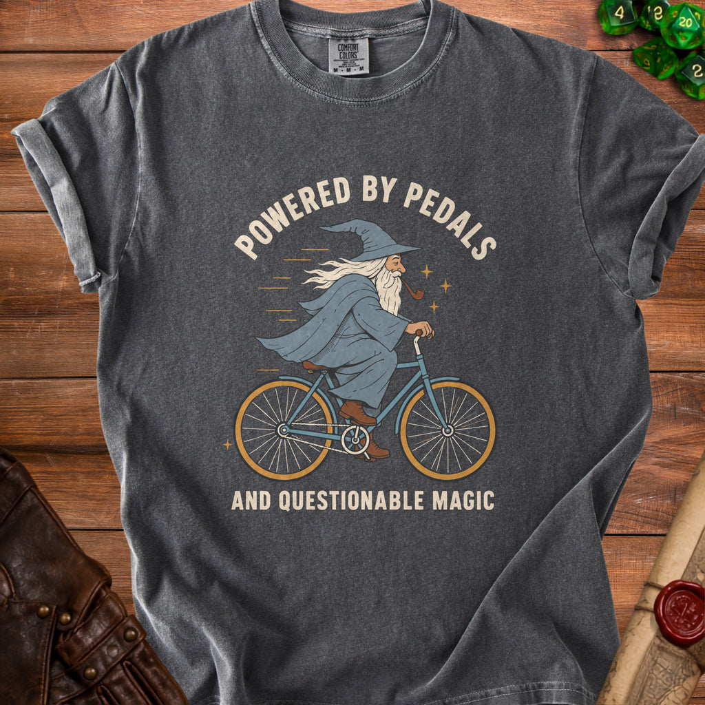 Gray t-shirt with wizard riding bicycle graphic and text "Powered by Pedals and Questionable Magic".