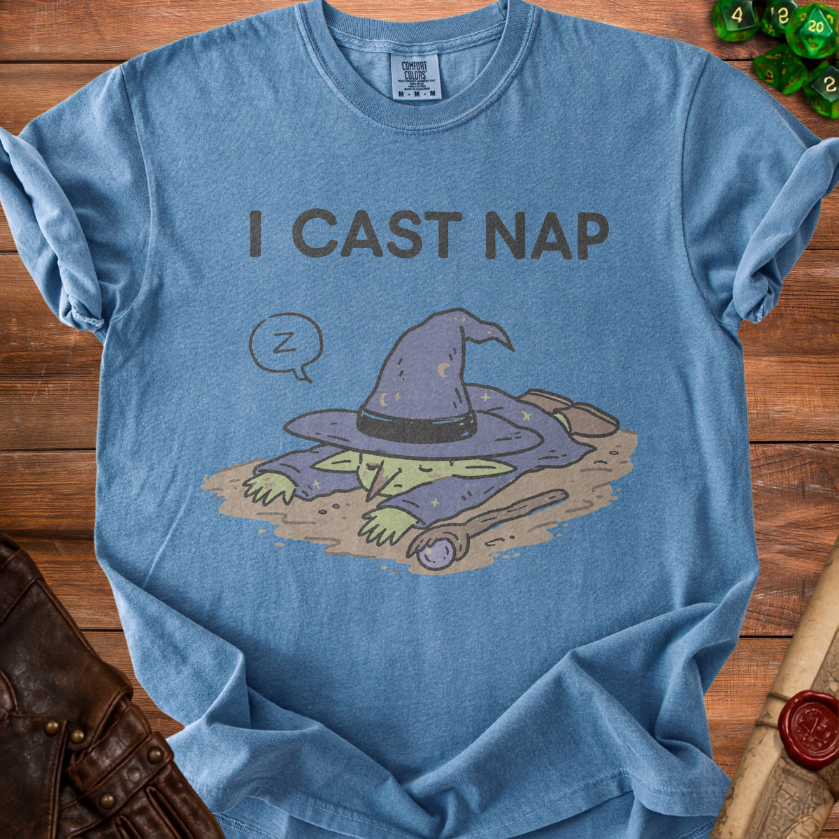 Blue t-shirt with text "I CAST NAP" and sleeping wizard graphic.