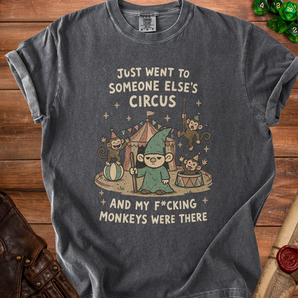 Dark grey t-shirt graphic: gnome and monkeys at a circus with text.