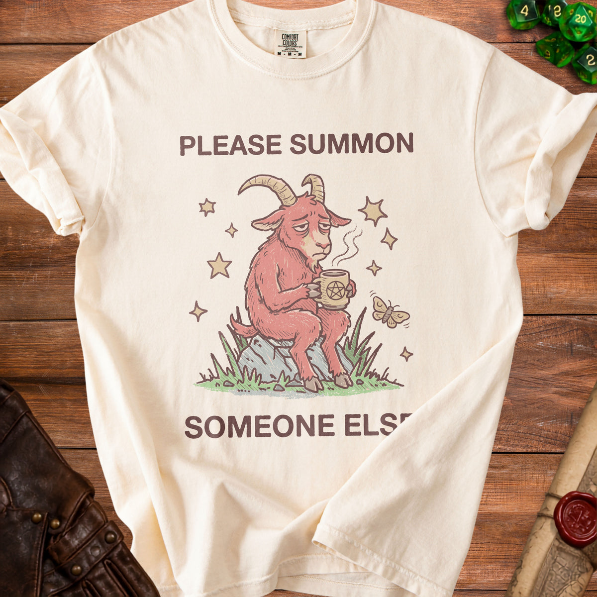 Cream t-shirt with "PLEASE SUMMON SOMEONE ELSE" and a tired goat holding a pentagram mug.