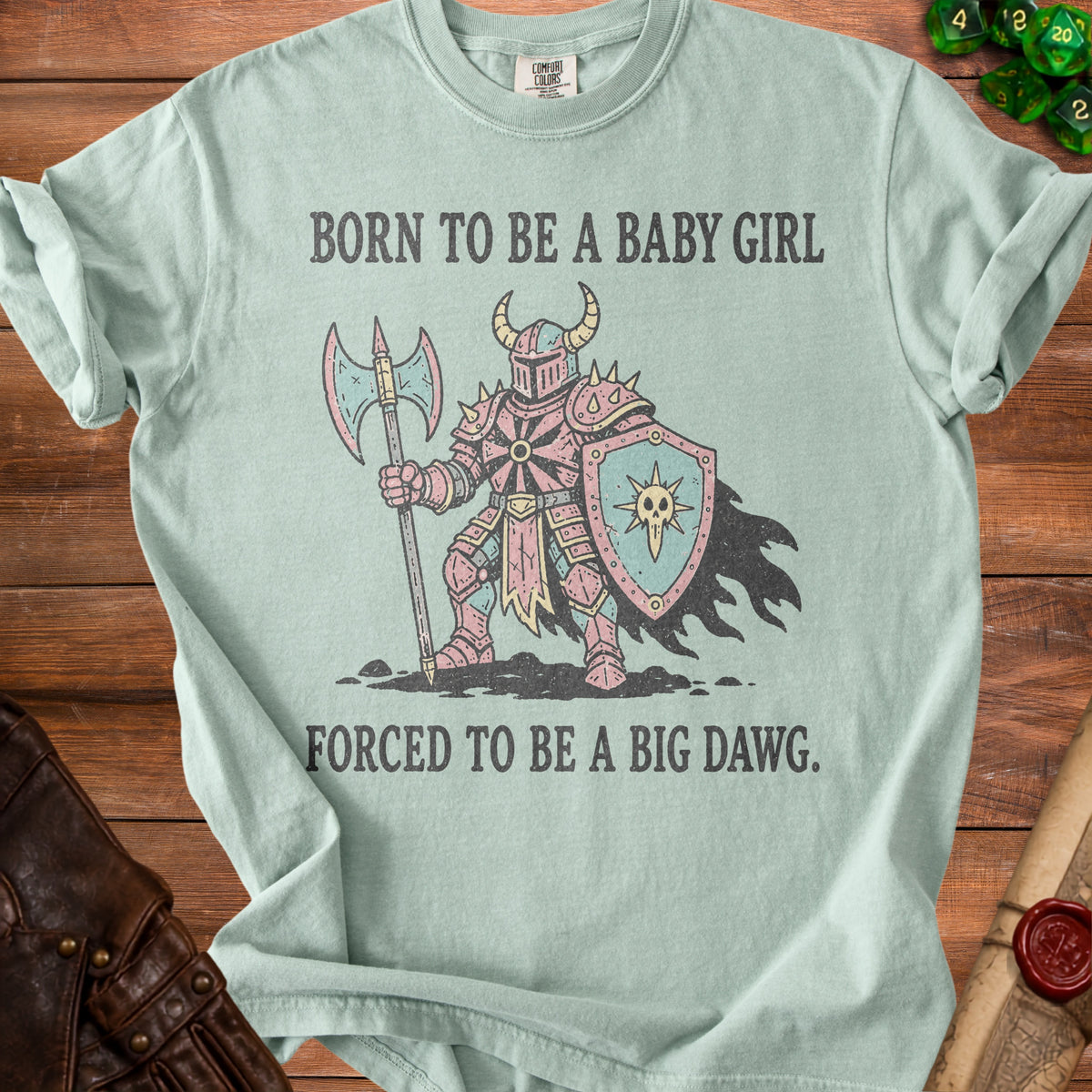 Light blue t-shirt with a knight graphic and text "BORN TO BE A BABY GIRL FORCED TO BE A BIG DAWG."