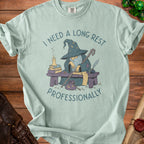 Light blue t-shirt with wizard reading a scroll and text "I NEED A LONG REST PROFESSIONALLY".