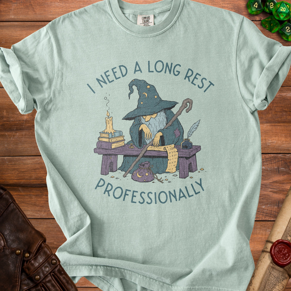 Light blue t-shirt with wizard reading a scroll and text "I NEED A LONG REST PROFESSIONALLY".