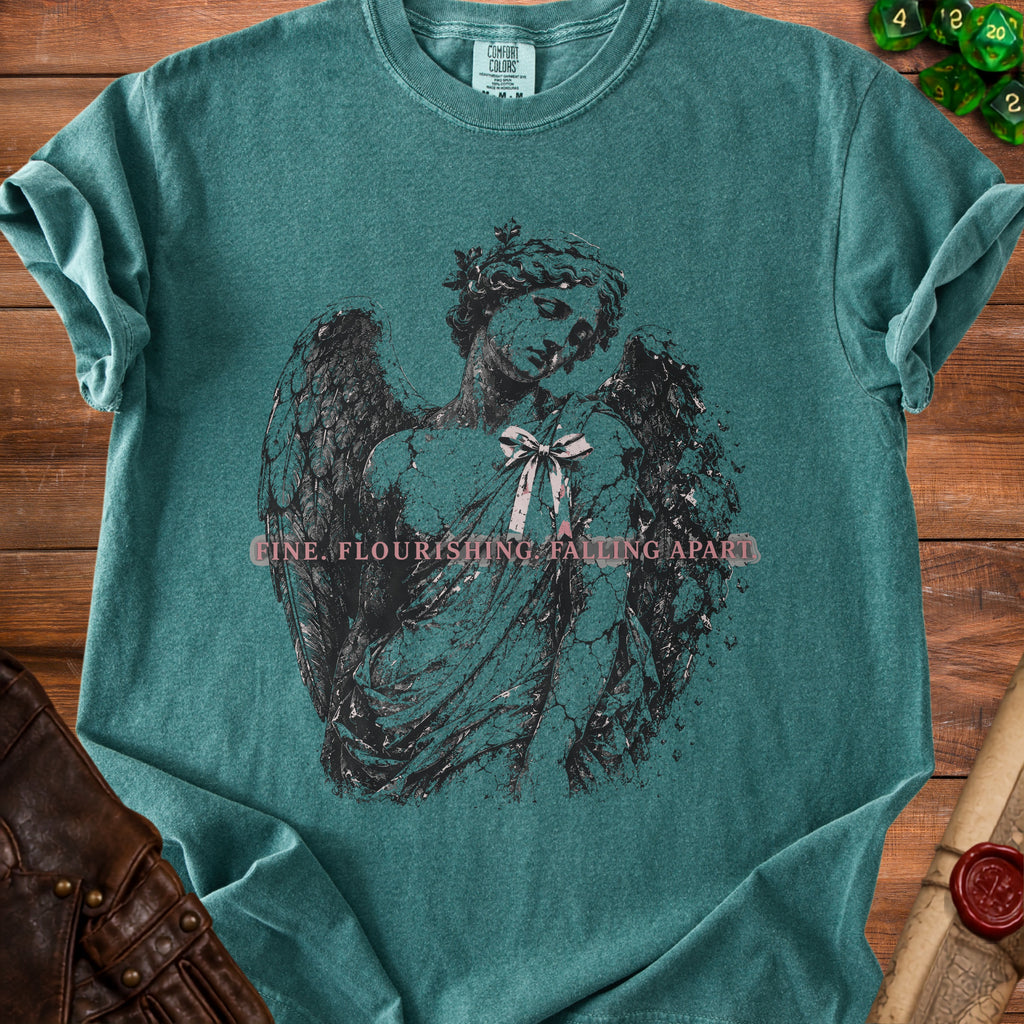 Teal t-shirt with a distressed angel graphic and text "FINE. FLOURISHING. FALLING APART."