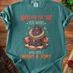 Teal t-shirt with dragon wearing a crown and ruff, holding tea, saying "Dress for the job you want. Who says I want a job?"
