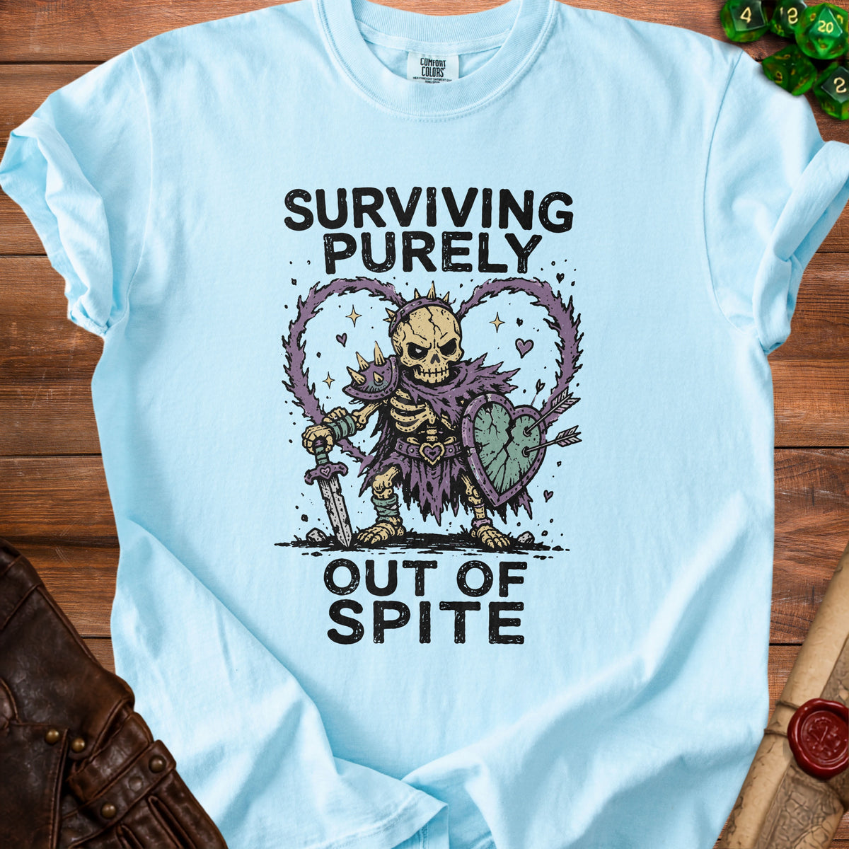Light blue t-shirt with skeleton warrior graphic and "Surviving Purely Out of Spite" text.