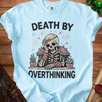 Light blue t-shirt with skeleton graphic and text "DEATH BY OVERTHINKING".