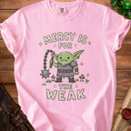 Pink t-shirt with a goblin graphic and the text "Mercy Is For The Weak".