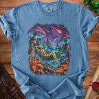 Blue t-shirt with a skeleton relaxing in a hammock with a psychedelic mushroom forest background.