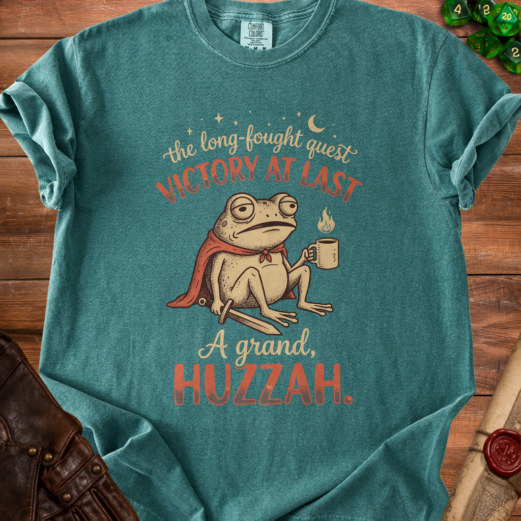 T-shirt with a cartoon frog wearing a cape, holding coffee, and text "Victory at Last" and "A grand, Huzzah."