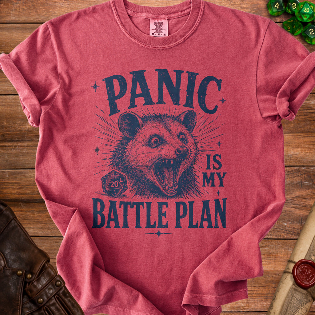 Red t-shirt with blue distressed graphic of a possum and text "PANIC IS MY BATTLE PLAN".