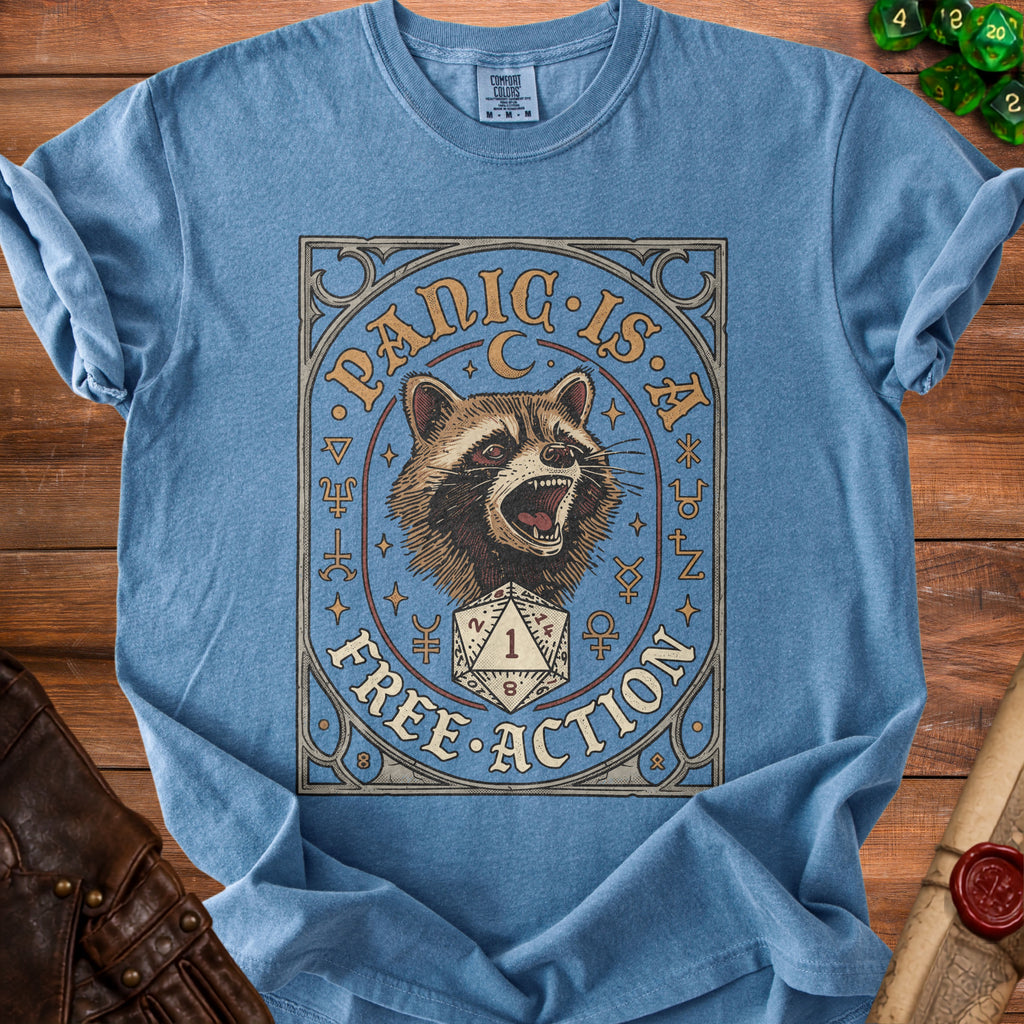 Blue t-shirt with a graphic of a raccoon and a d20 die reading 1, with text "PANIC IS FREE ACTION".