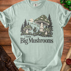 Light green t-shirt with a graphic of a gnome and large mushrooms, reading "i love Big Mushrooms".