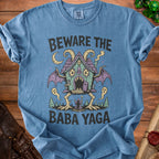 Blue t-shirt with "Beware The Baba Yaga" text and a Baba Yaga house illustration.