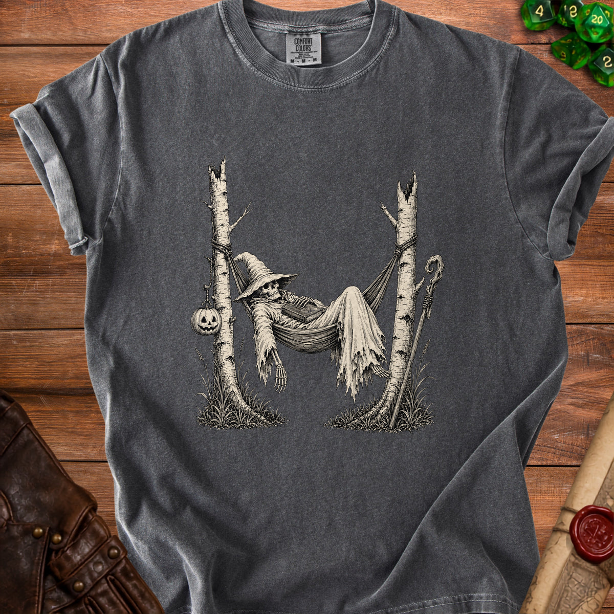 Skeleton in witch hat resting in hammock between two trees with pumpkin.